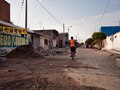 kids riding home through the streets of Pisco, Peru