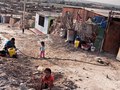 a family receiving their limited daily water supply, back streets of Pisco, Peru