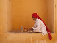 An Indian man uses his bare hands to consume a simple homemade lunch consisting of naan and water in Jaipur, India.