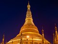Two men walk round the illuminated golden dome of the Shwedagon Pagoda in Yangon, Myanmar.