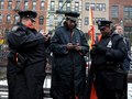 New York City police officers check thier cell phones during the2012 Lunar Holiday in the chinatown district of Manhattan.attan