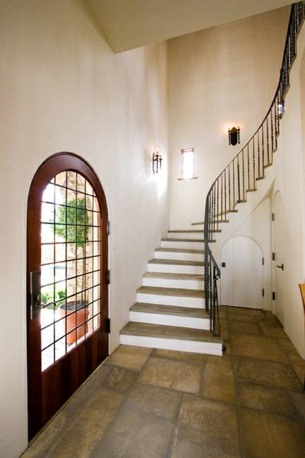 The front door is mahogany with leaded glass; the stair winds up the tower.